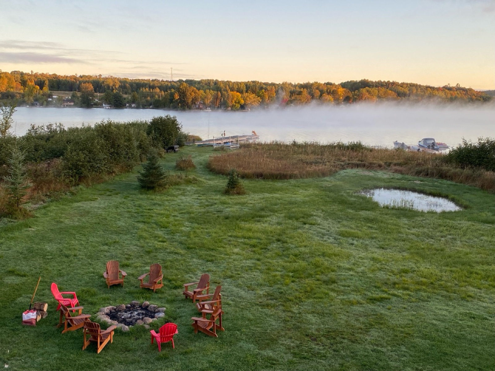 Morning mist floating over the lake beyond the firepit